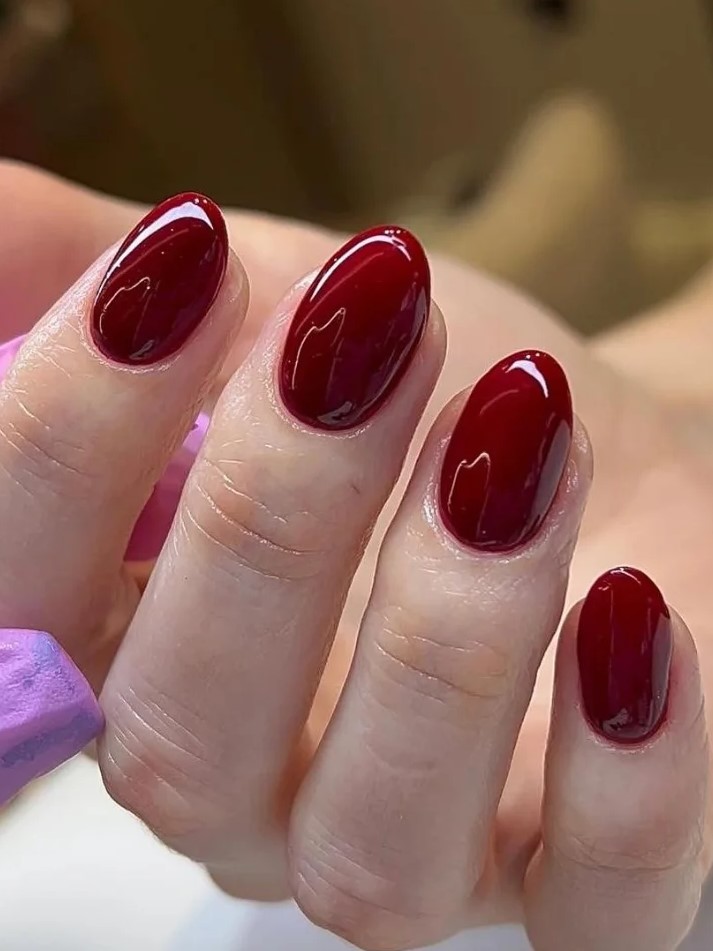 Primo piano di una manicure BIAB rosso scuro