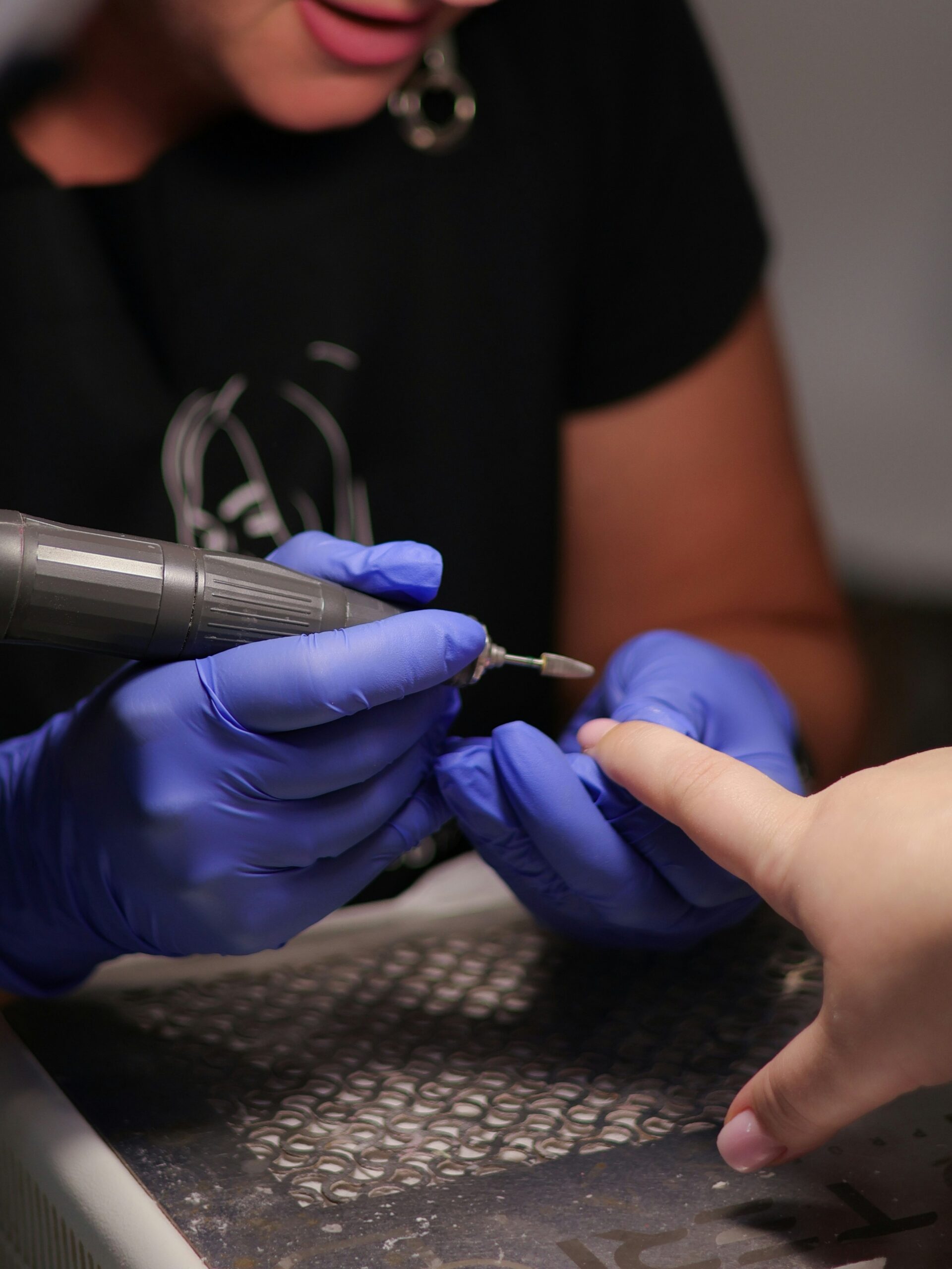 Onicotecnica che utilizza la fresa in salone per rimuovere una manicure BIAB