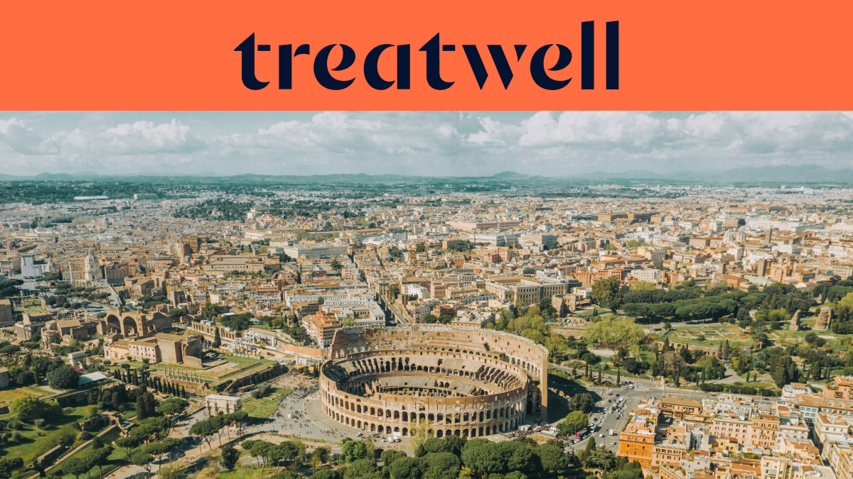 Vista aerea dall'alto di Roma con il Colosseo in primo piano. La città storica si estende fino all'orizzonte sotto un cielo coperto. Un grande banner arancione in alto mostra il logo 'treatwell'.